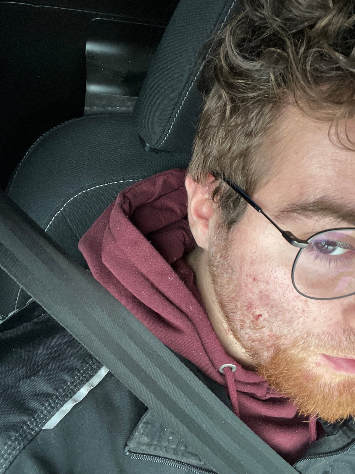 Person rests in car seat during journey in Pernik