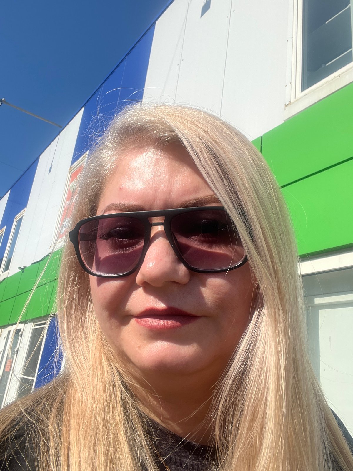 Woman takes selfies around buildings in Glazov, Russia