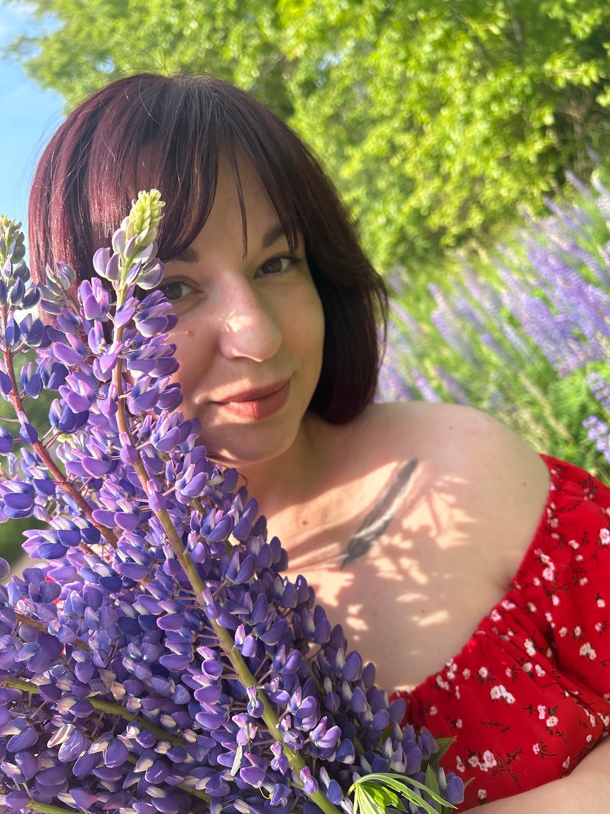 Woman poses with lupine flowers in Russian field photoshoot