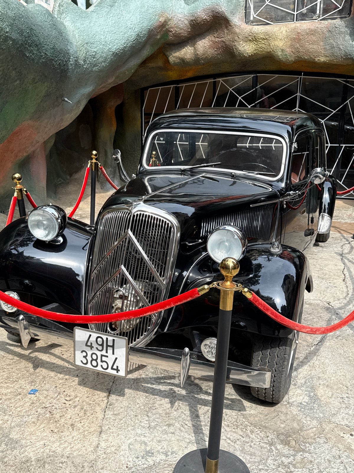 Tourist visits vintage car display, Crazy House in Da Lat