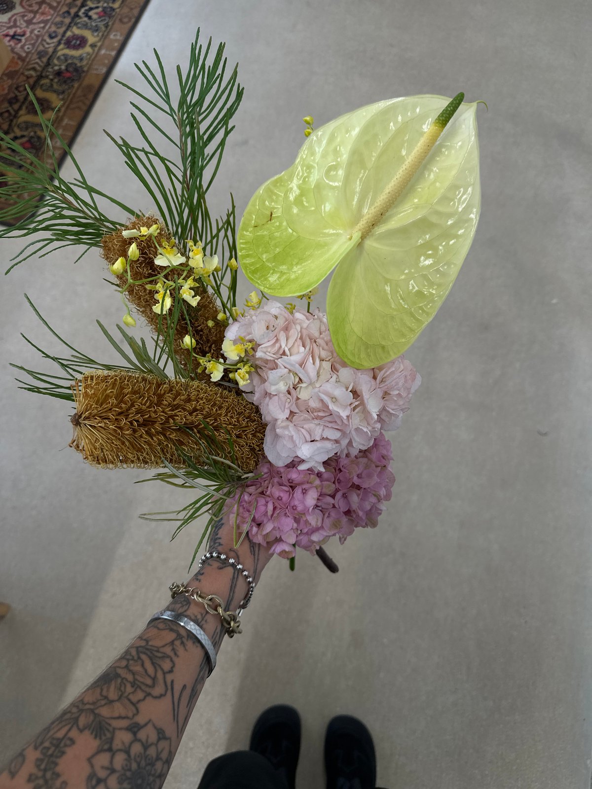 Tattooed florist arranges bouquets in Paris workspace
