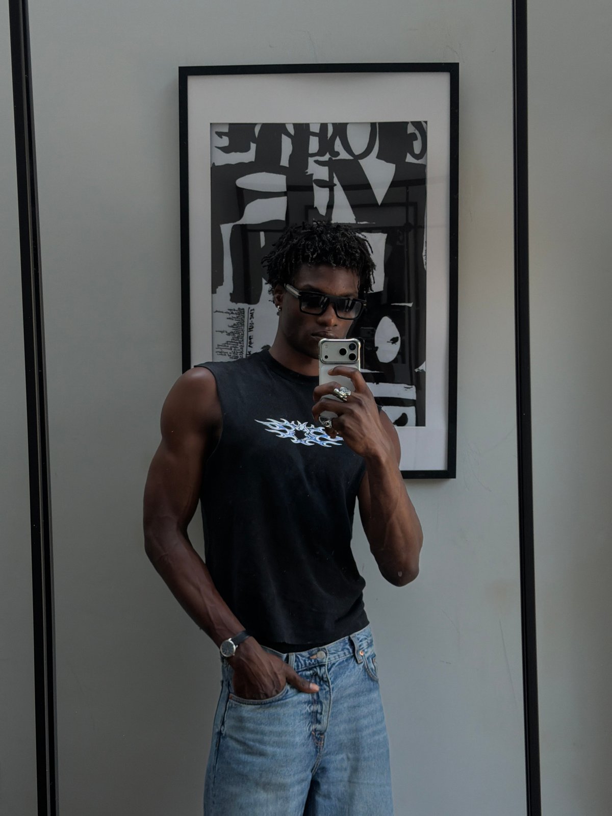 Mirror selfie showing flame graphic tee and light blue denim