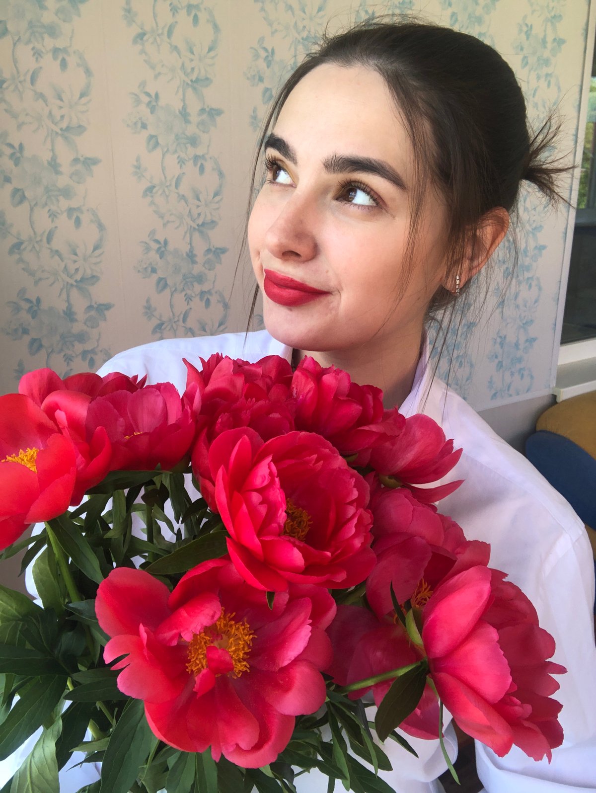 Woman photographed with pink peonies in Noviy, Russia