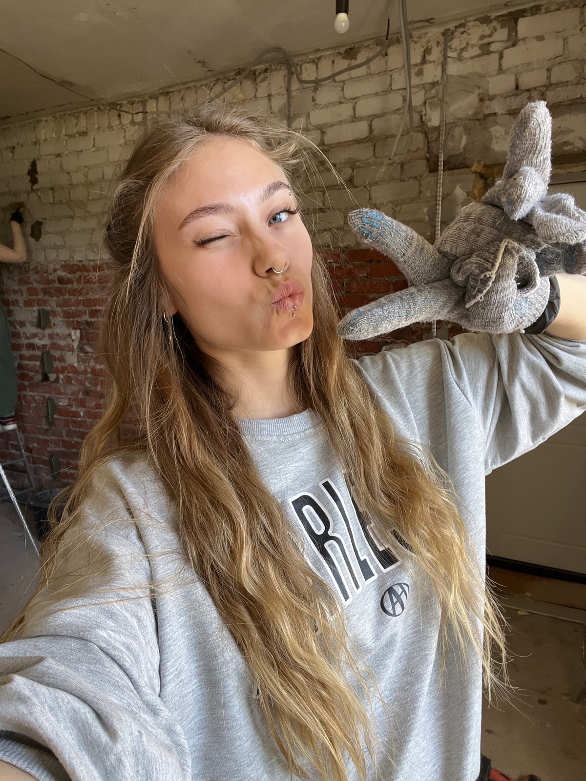 Woman with work gloves photographed indoors in Foki, Russia