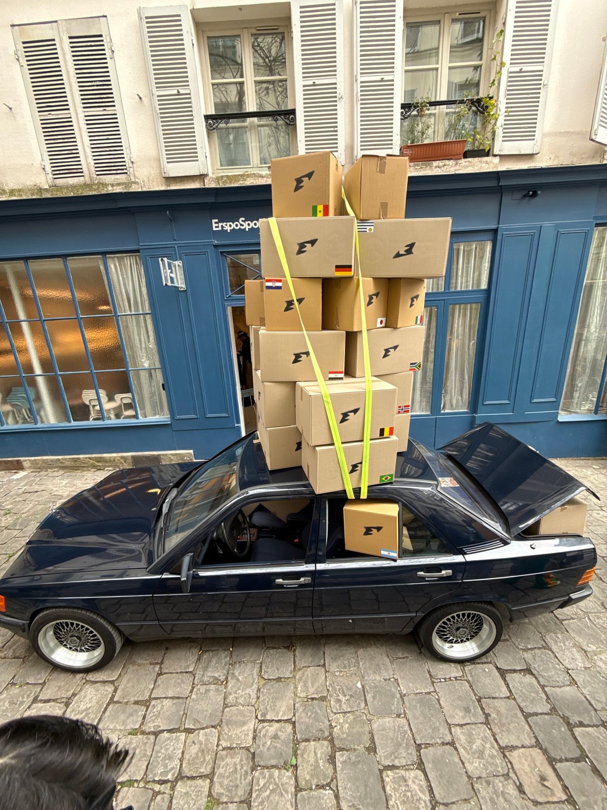 Person moves boxes with blue car in Paris