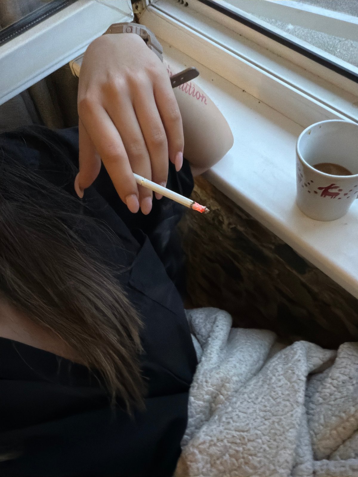 Early morning coffee and cigarette by window in Sofia