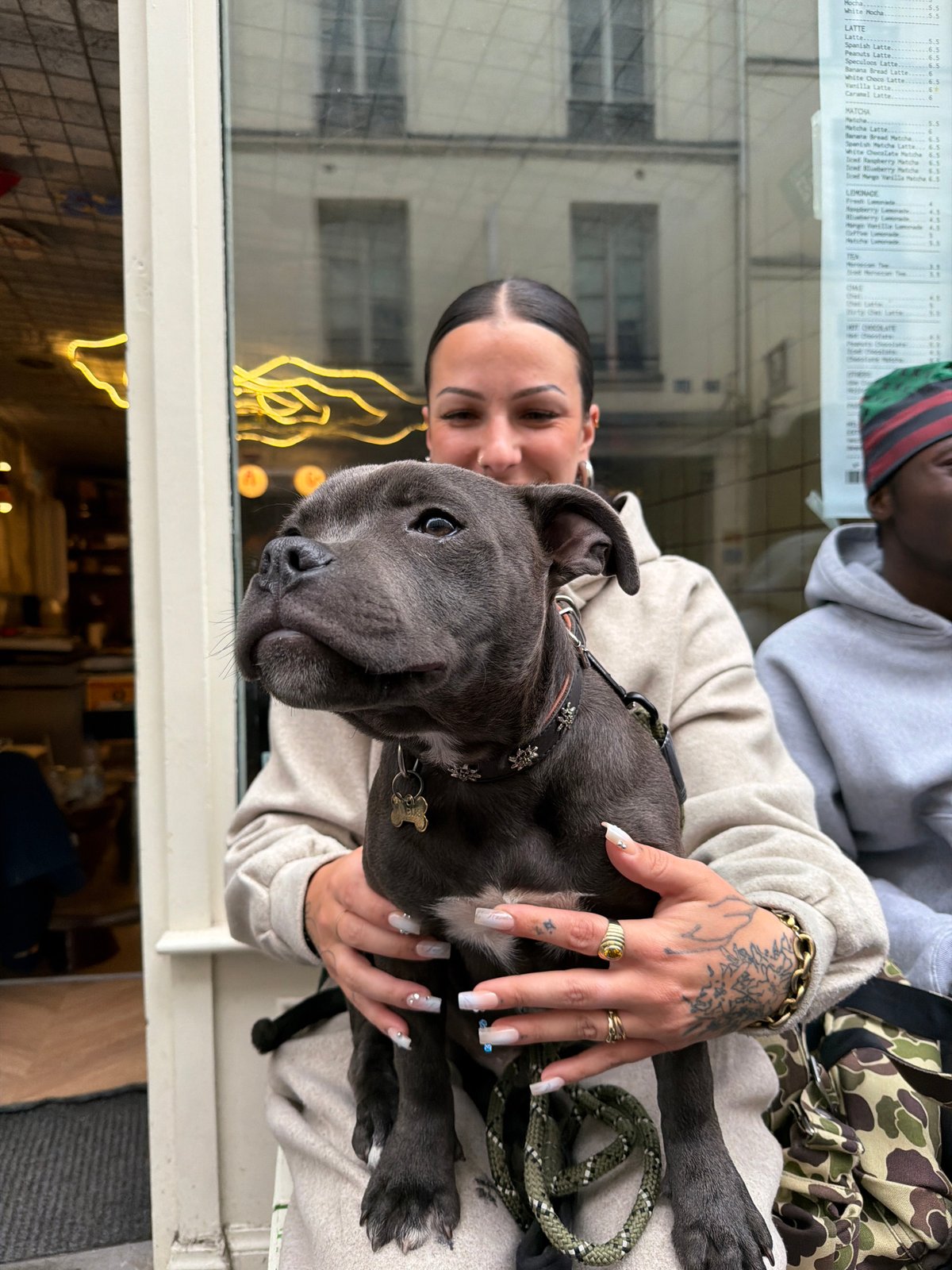 Woman poses with grey pitbull puppy in Paris apartment