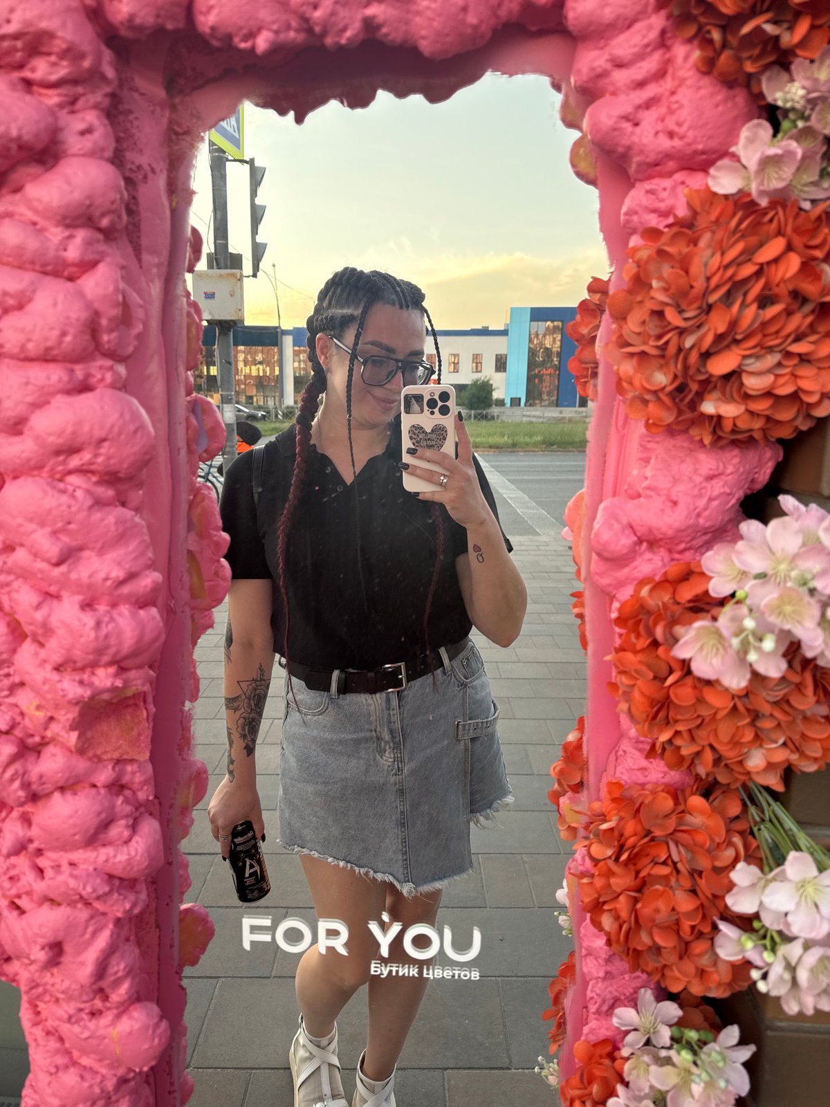 Woman documents urban selfie session near colorful city buildings