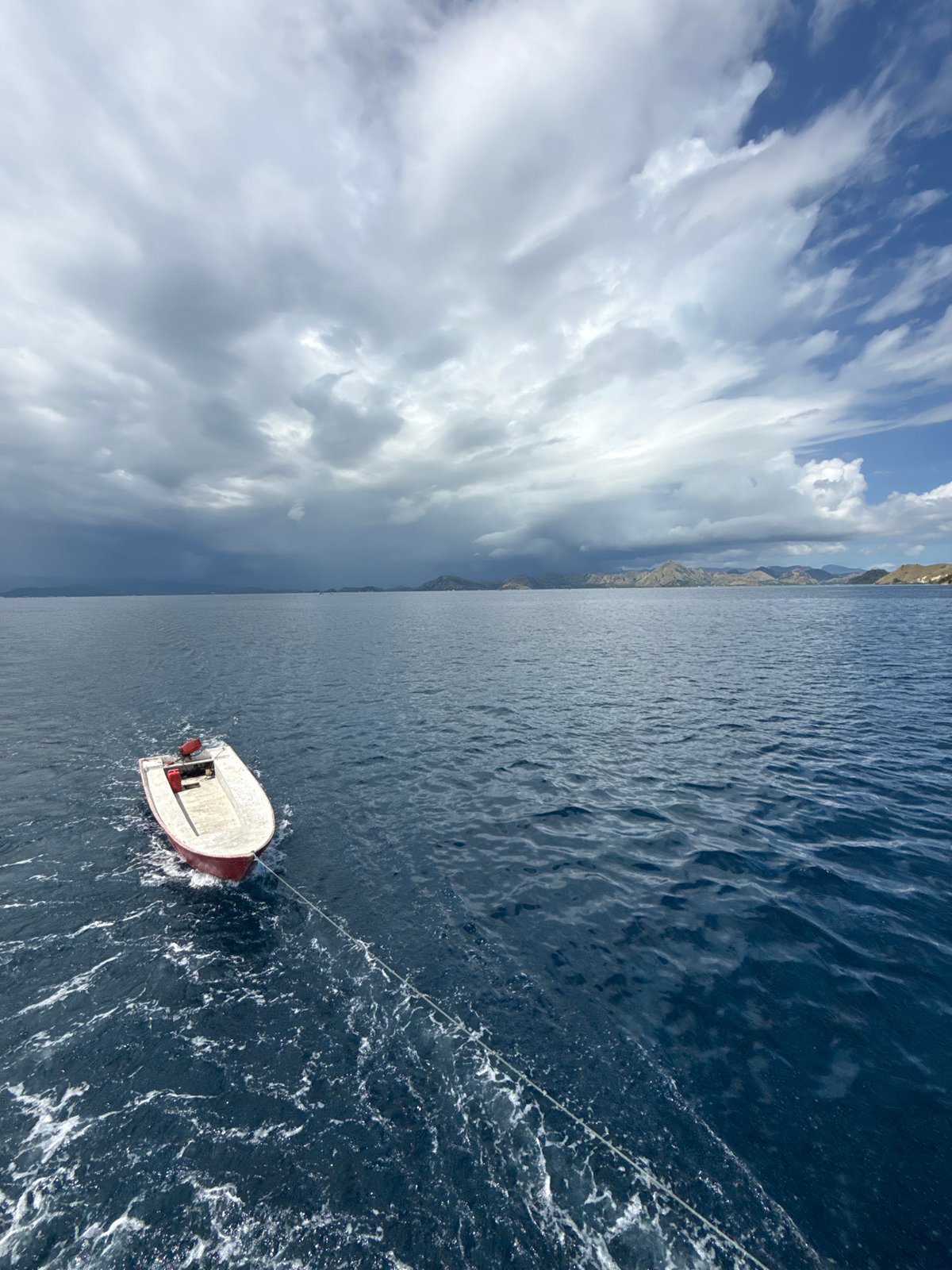 Small boat towed across waters near Pasir Putih, Indonesia