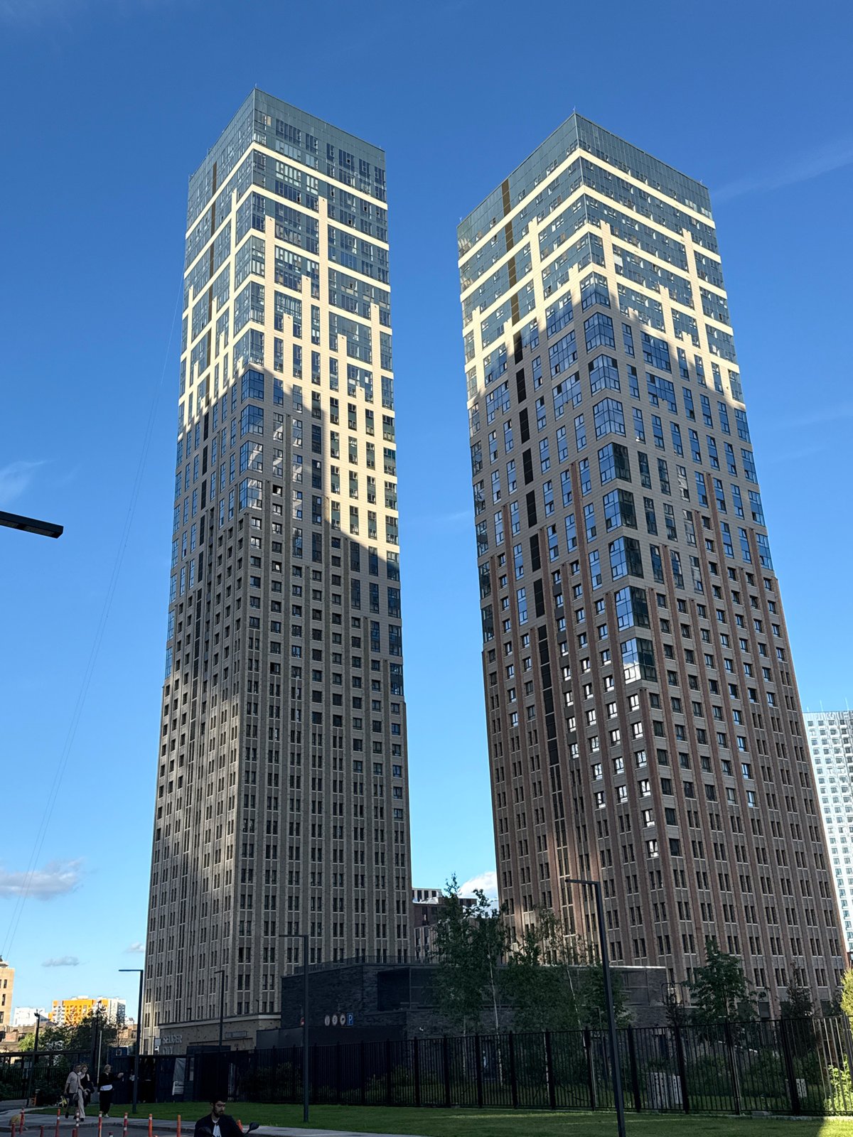 Twin skyscrapers and a dog walk in an urban scene