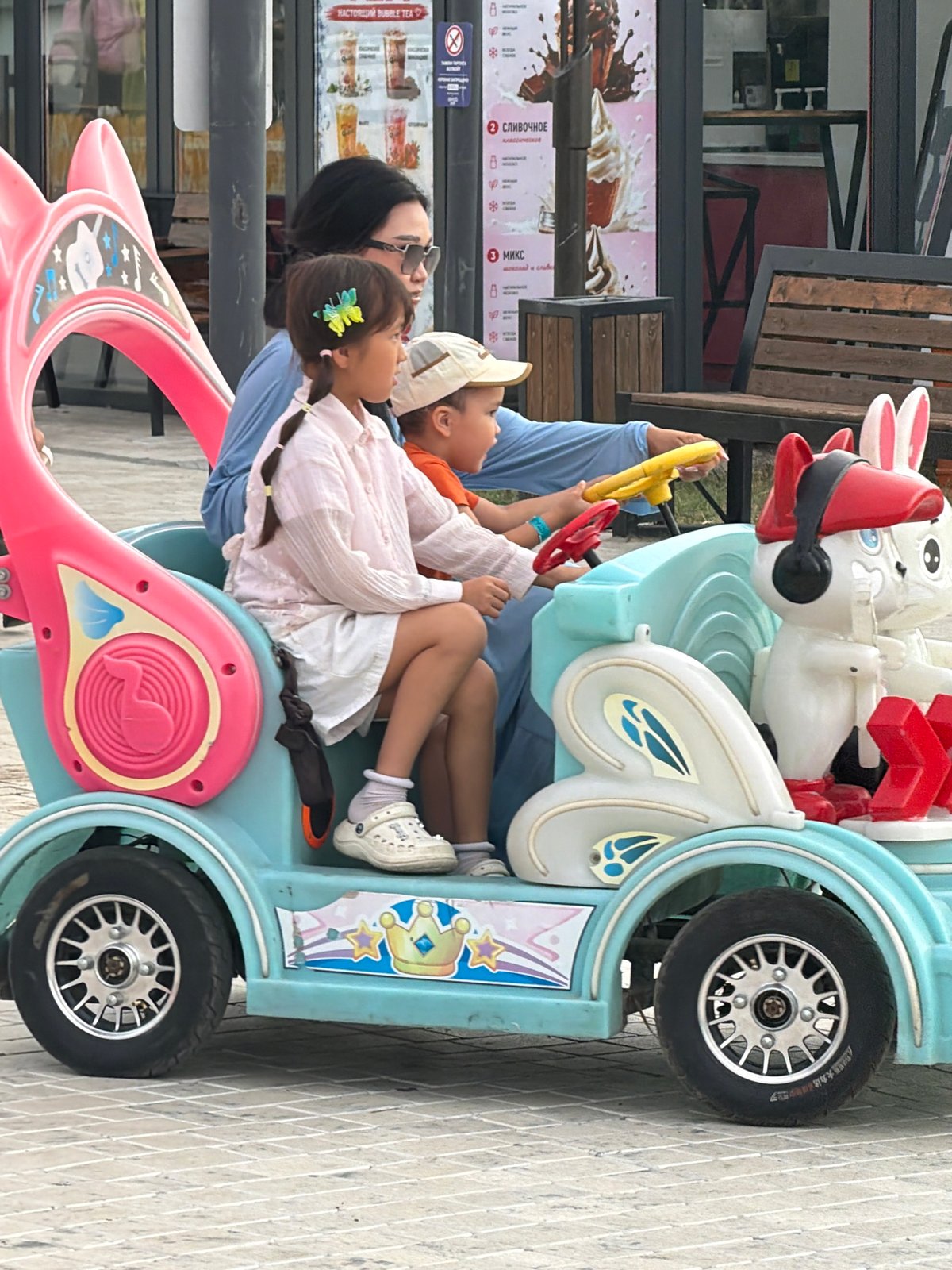 A busy outdoor amusement park on a late afternoon visit