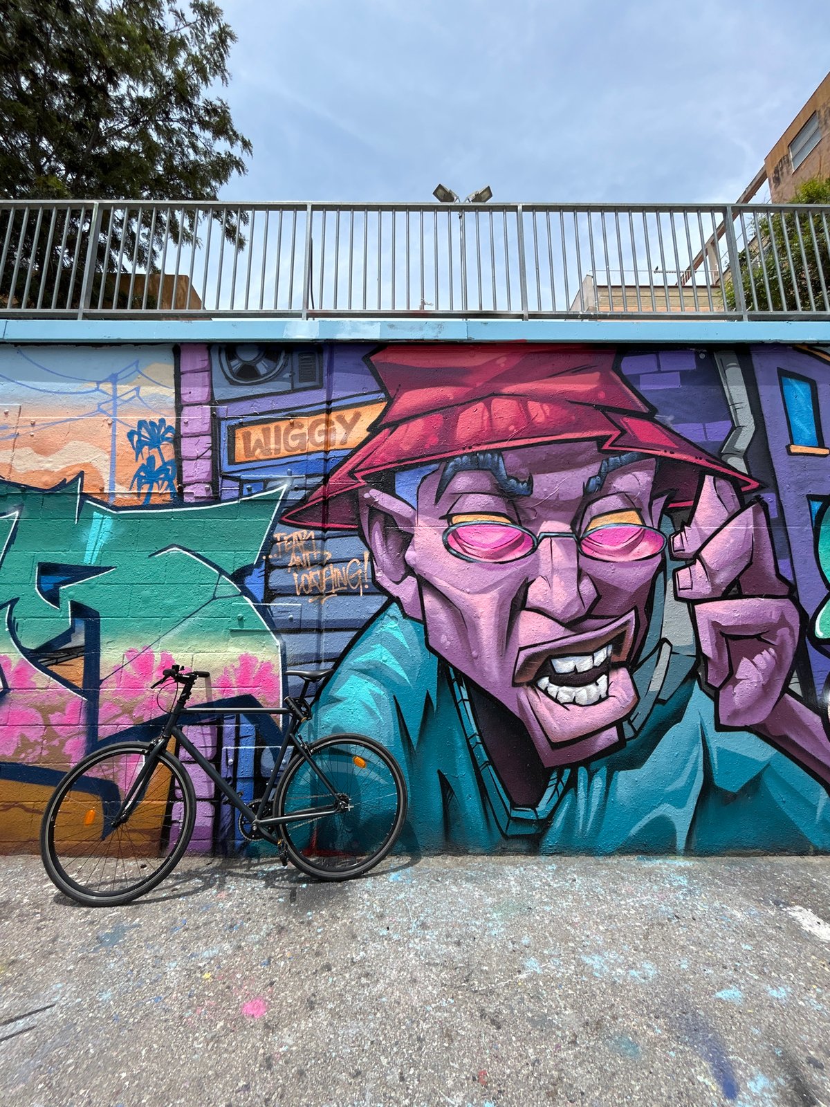 Man poses with basketball against colorful Barcelona street art