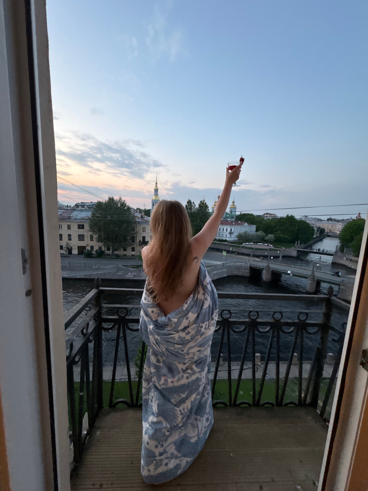 Woman enjoys strawberry cocktails on St. Petersburg balcony