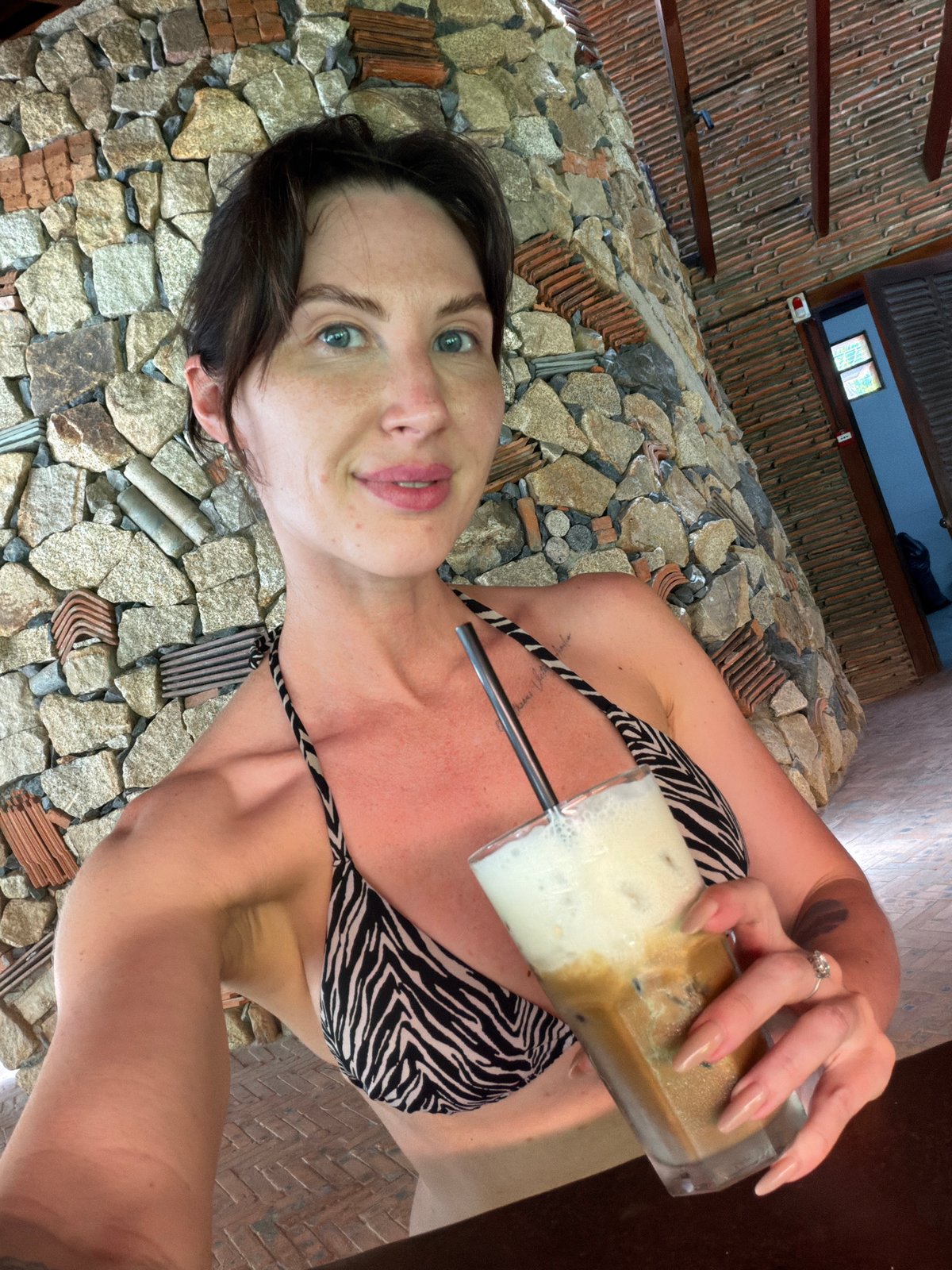 Woman enjoys morning coffee at Vietnamese resort cafe