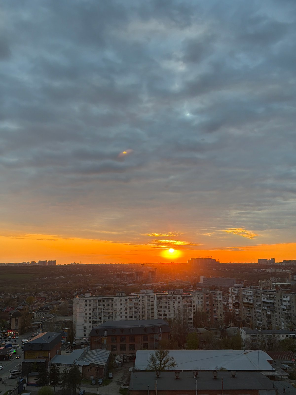 Sunset illuminates urban construction site with cranes and buildings