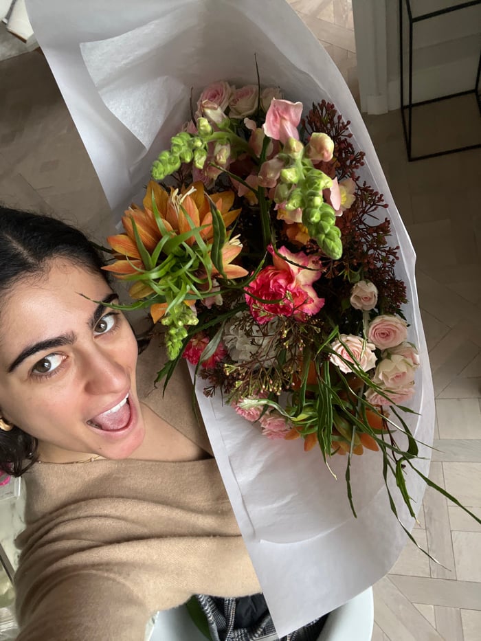 Woman photographed with vibrant flower bouquet in Paris