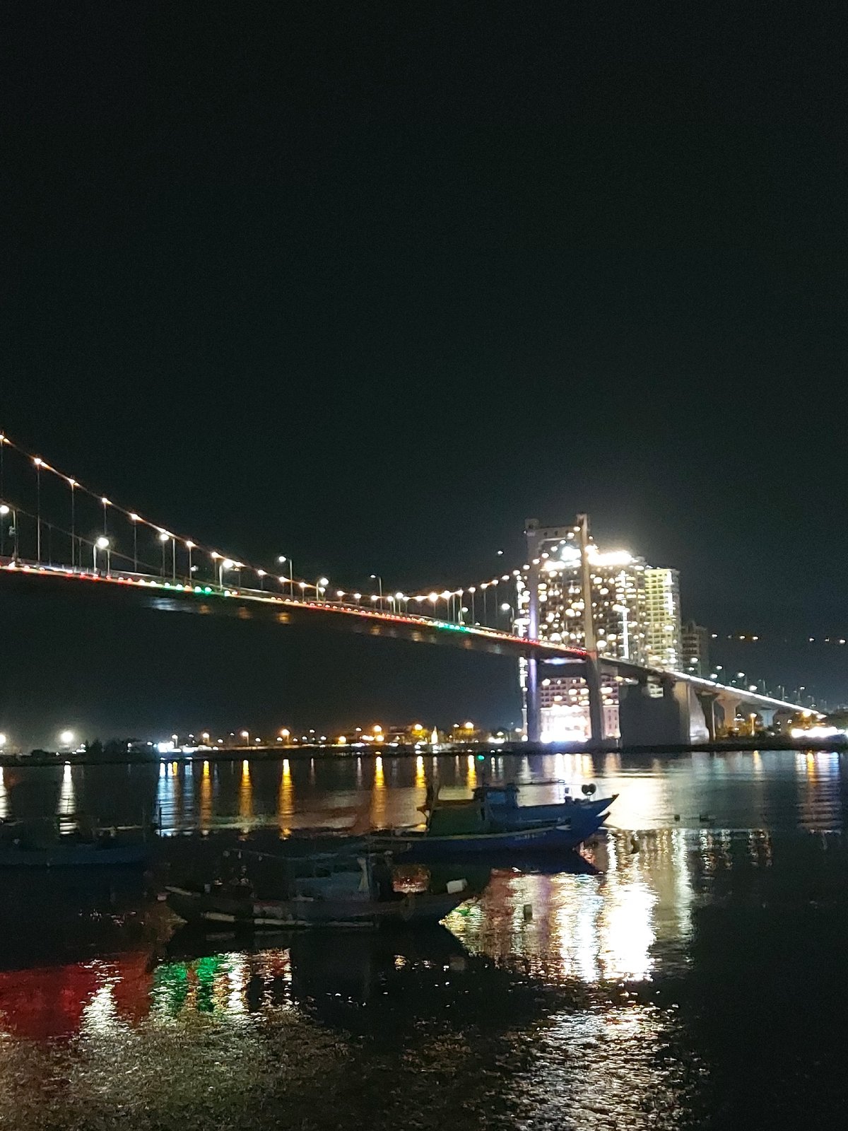 Da Nang's lit-up bridges reflecting across the Han River at night