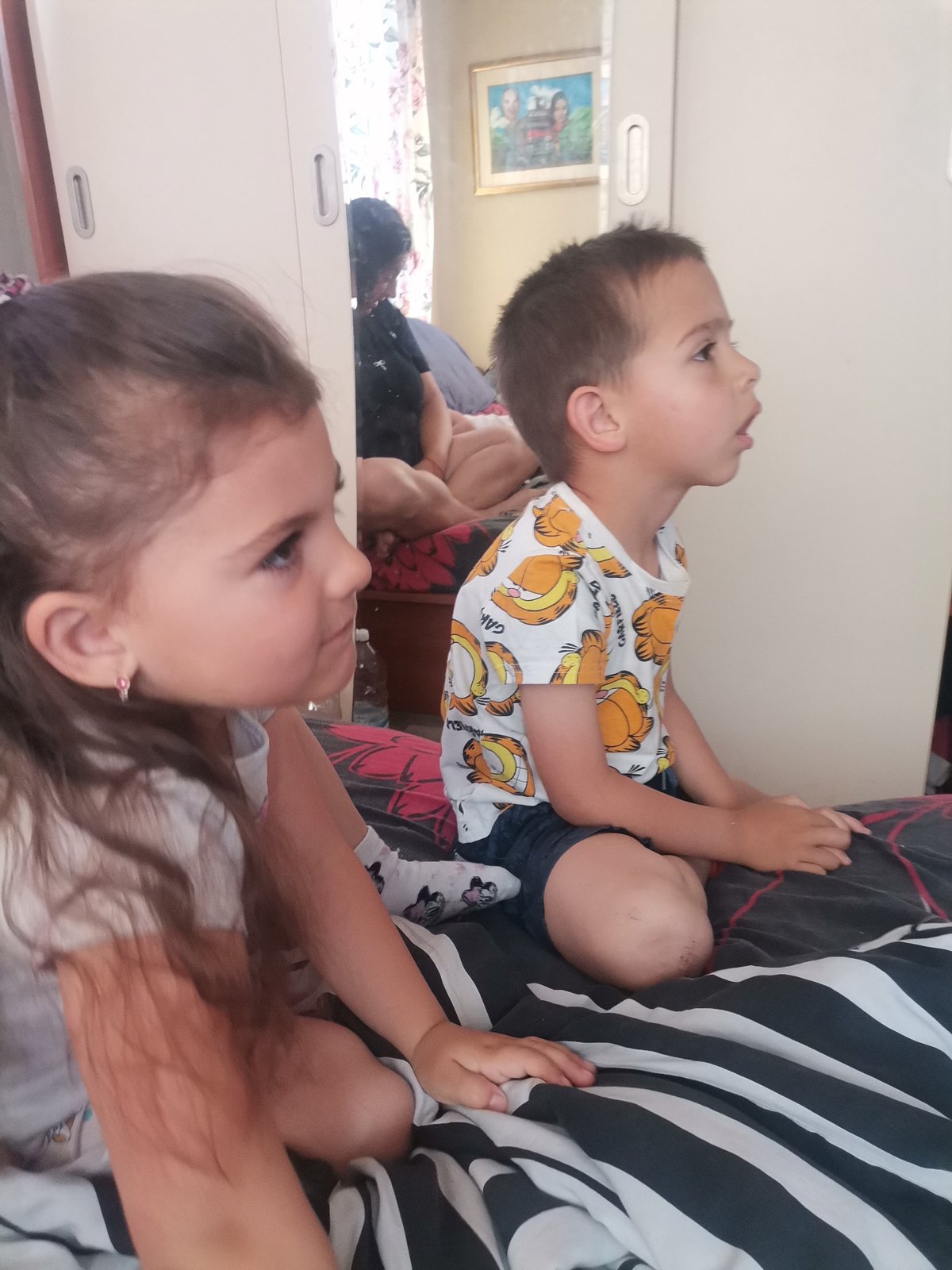 Family captures quiet indoor moment with children on bed