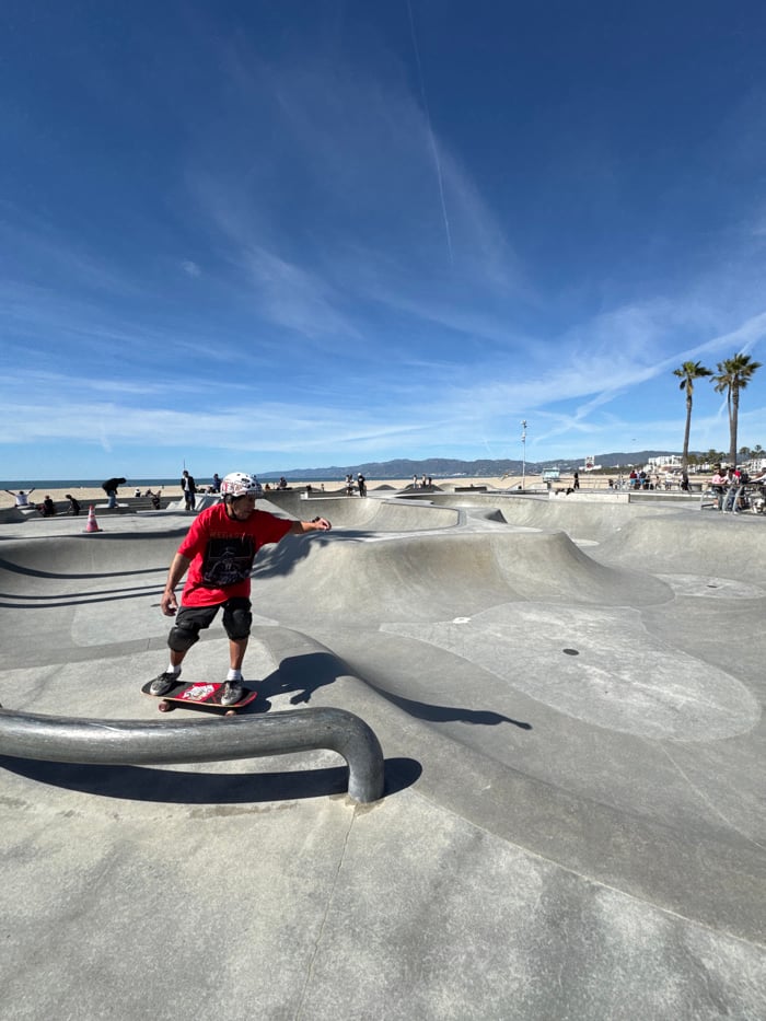 Skateboarder performs rail trick at beachside Los Angeles skatepark