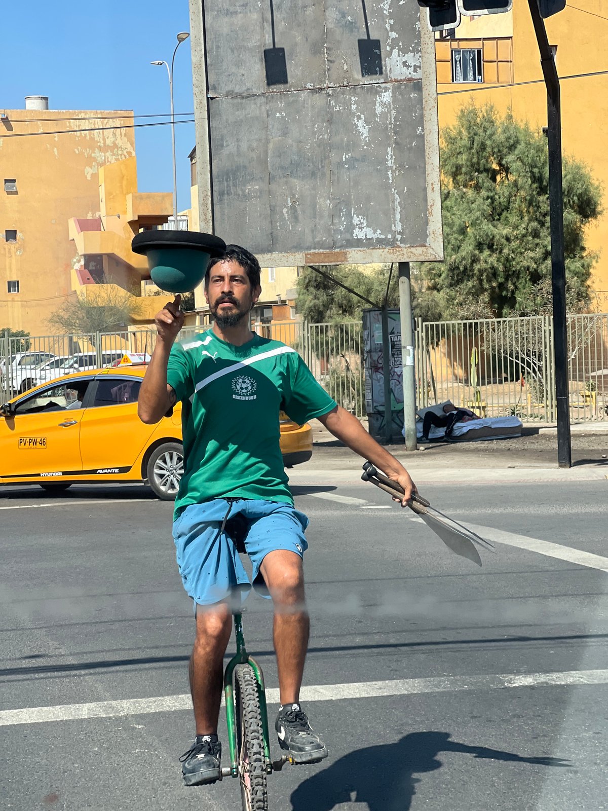 Unicyclist juggles machetes at Arica crosswalk, workers repair nearby infrastructure