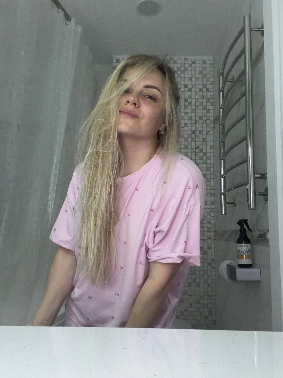 Woman dries hair in Votkinsk bathroom; dog sleeps nearby