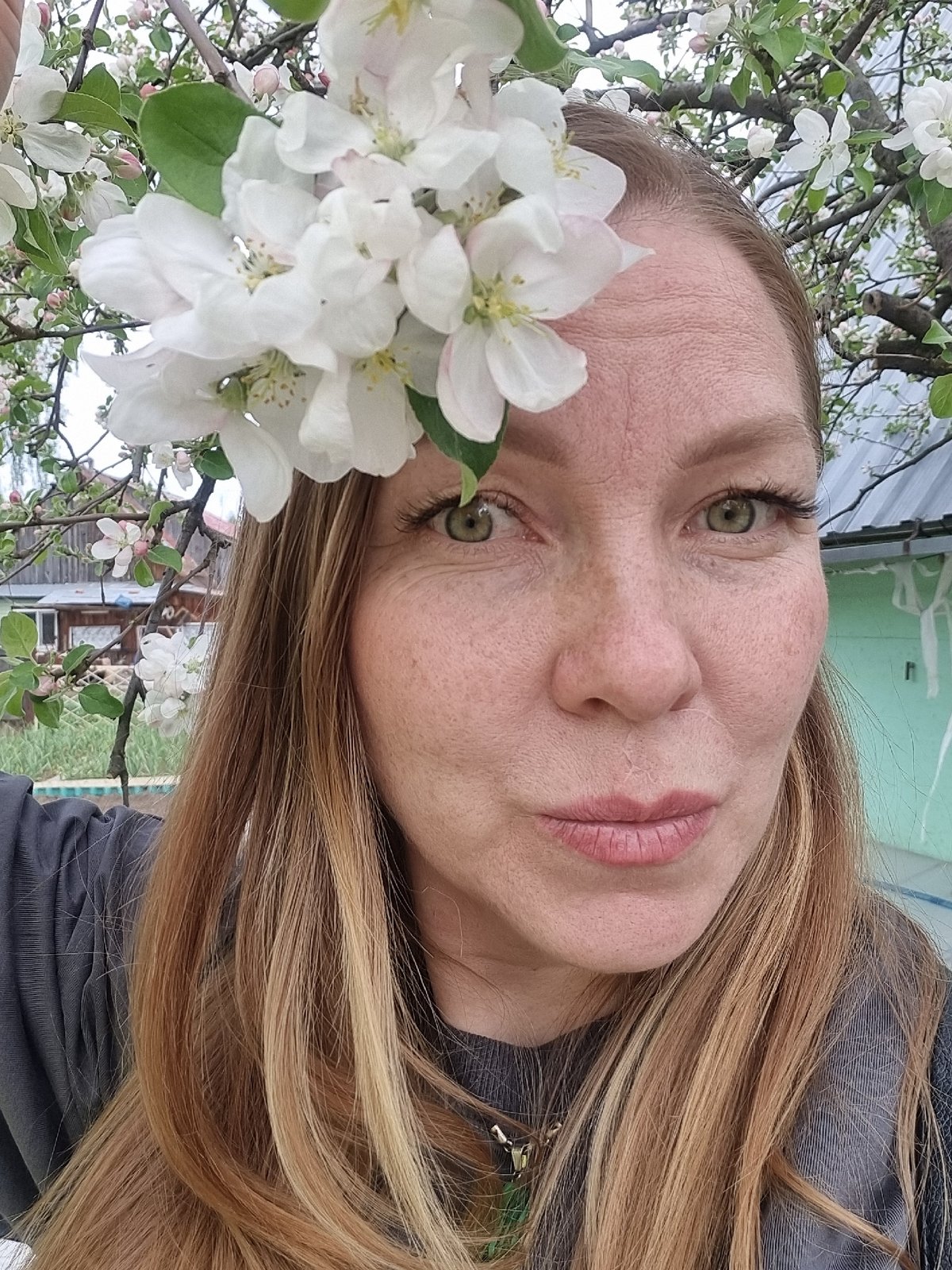 Woman photographs spring blossoms in Chaikovsky, Russia