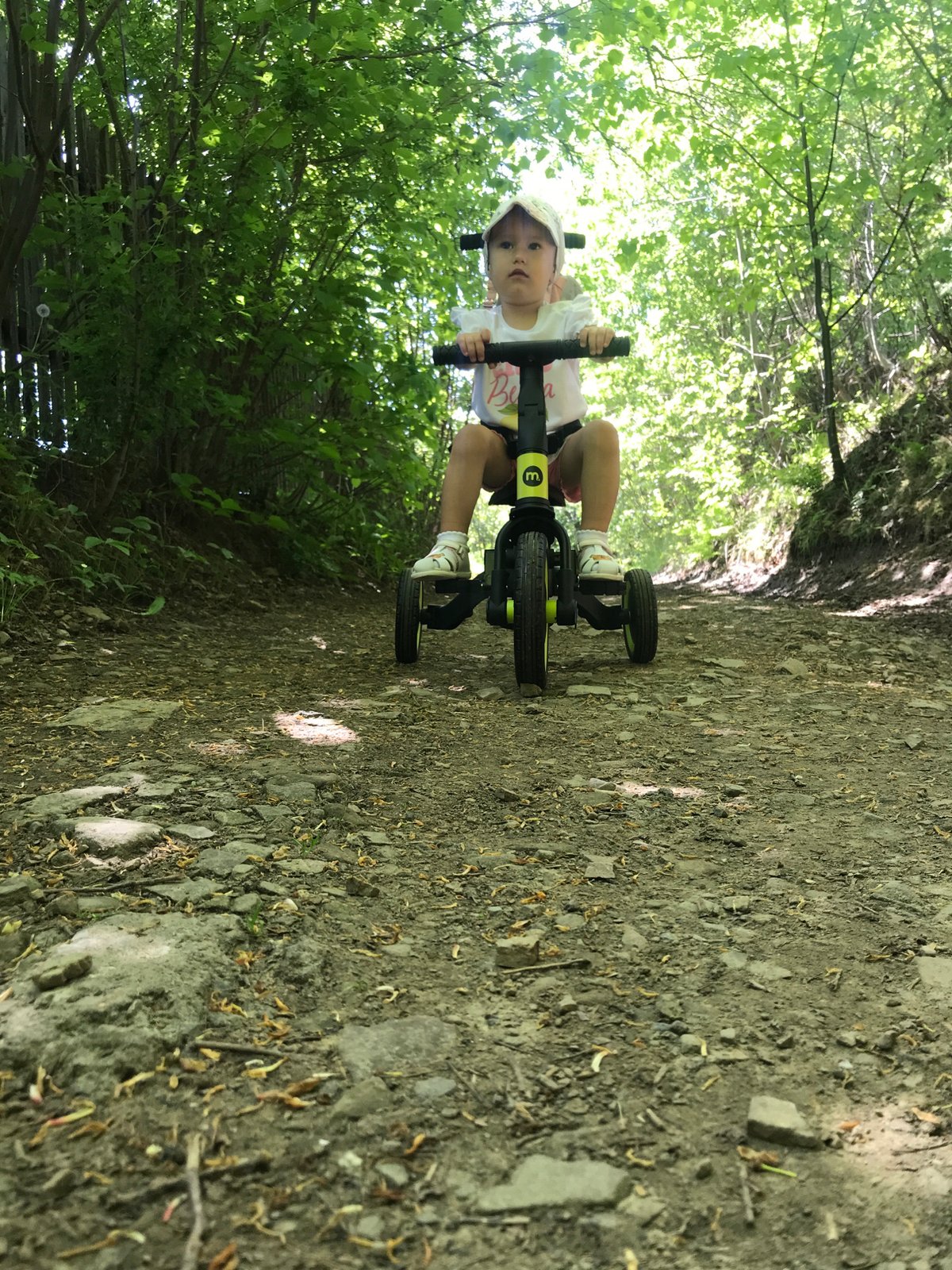 Child rides tricycle during family outing in Wisła, Poland
