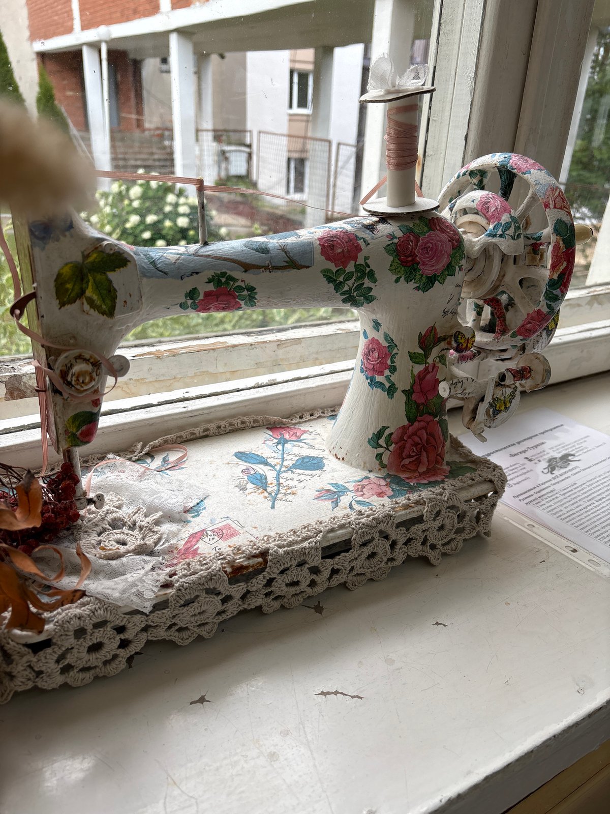 Floral-painted decorative sewing machine on a Vitsebsk windowsill