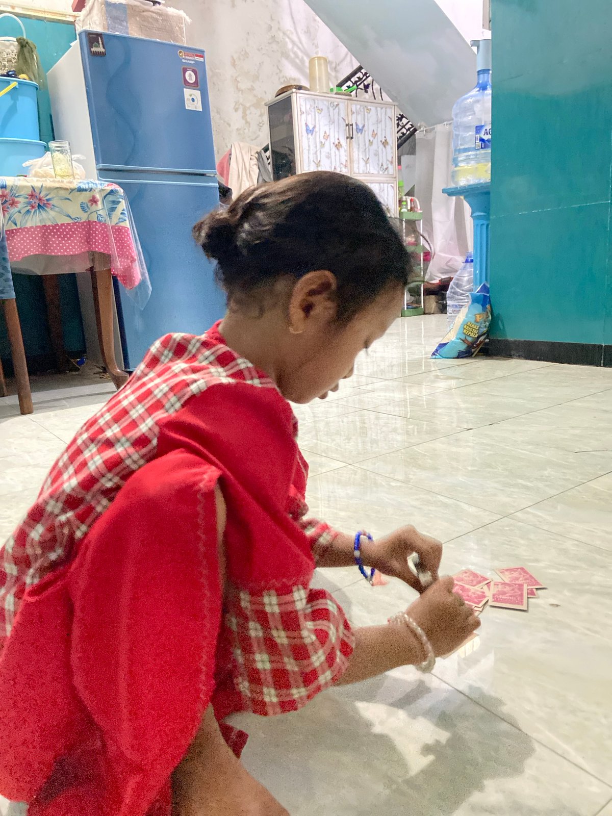 Child plays with cards at home in Gelam