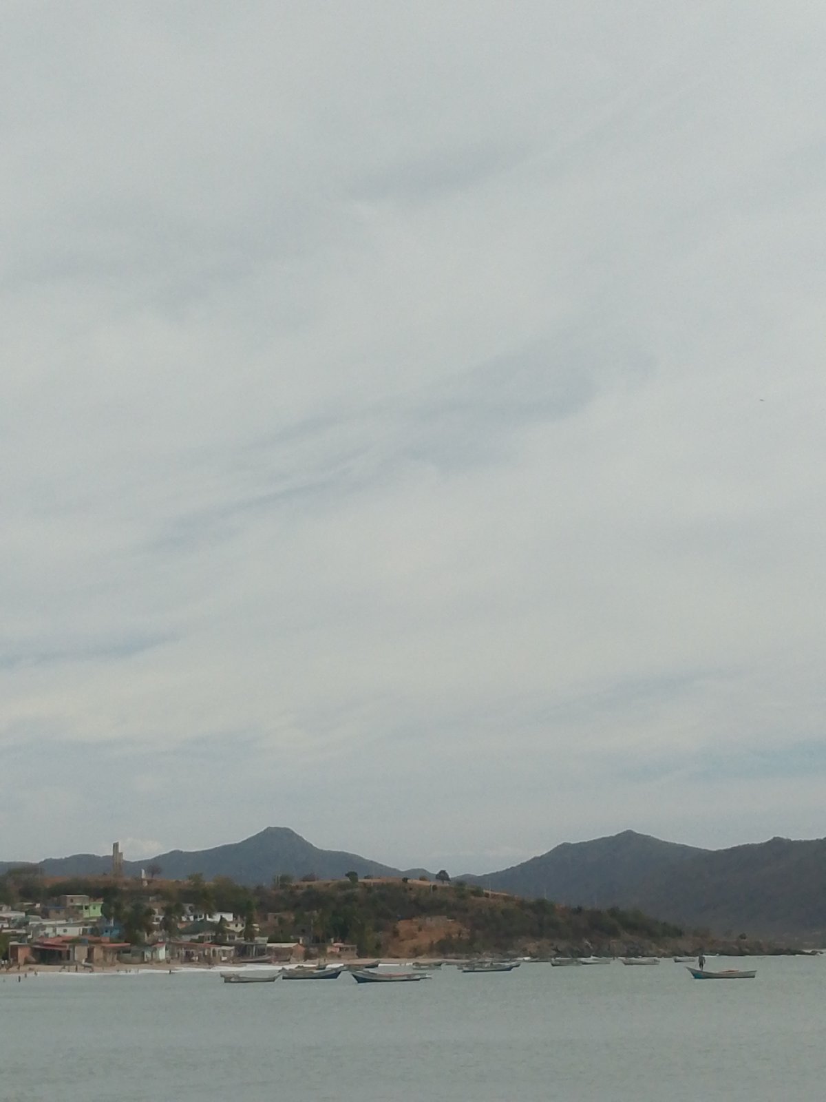 Busy afternoon at Juan Griego beach under cloudy skies