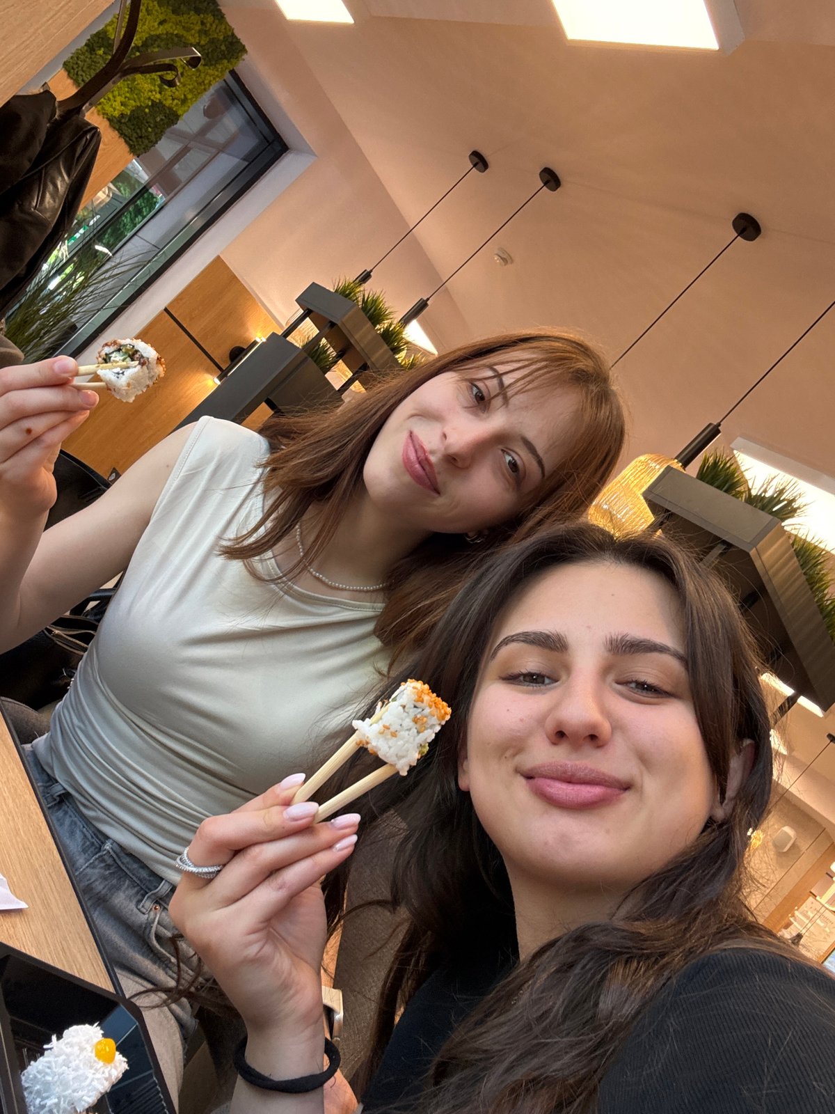 Two women share sushi meal in Sofia indoor venue