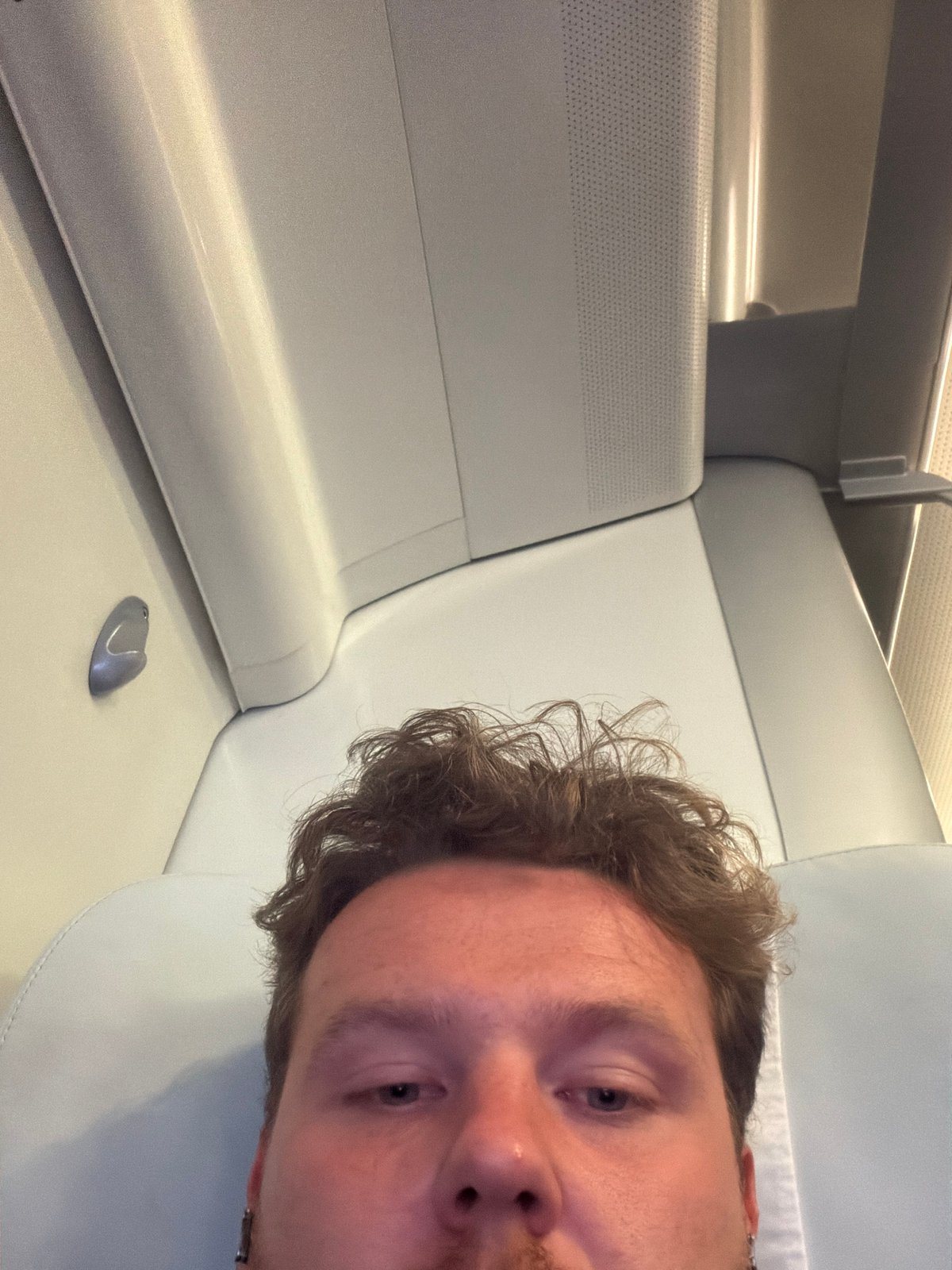Man takes selfie in modern transport compartment, Milton Keynes