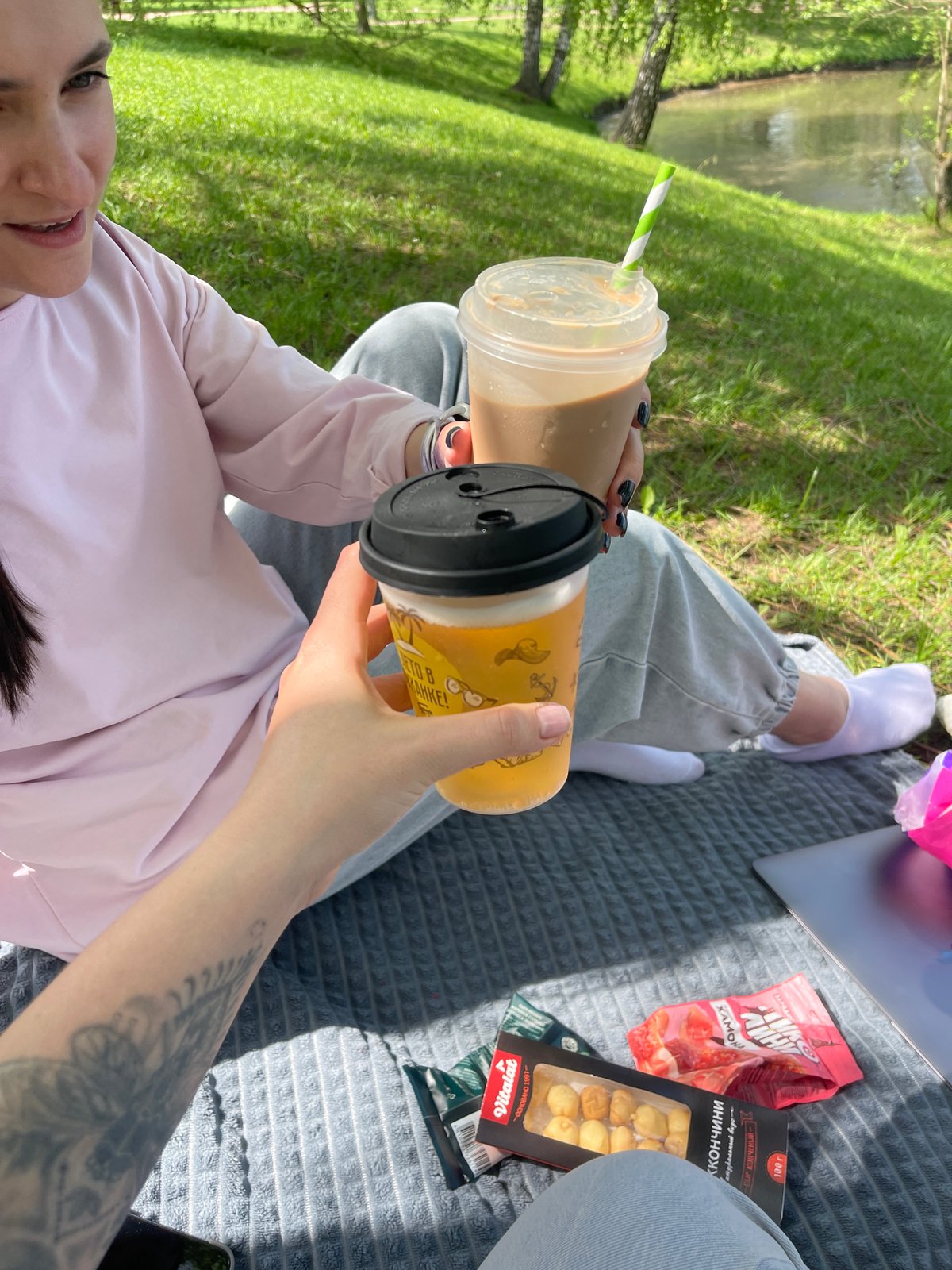 Moscow parkgoer enjoys morning picnic by water with beverages