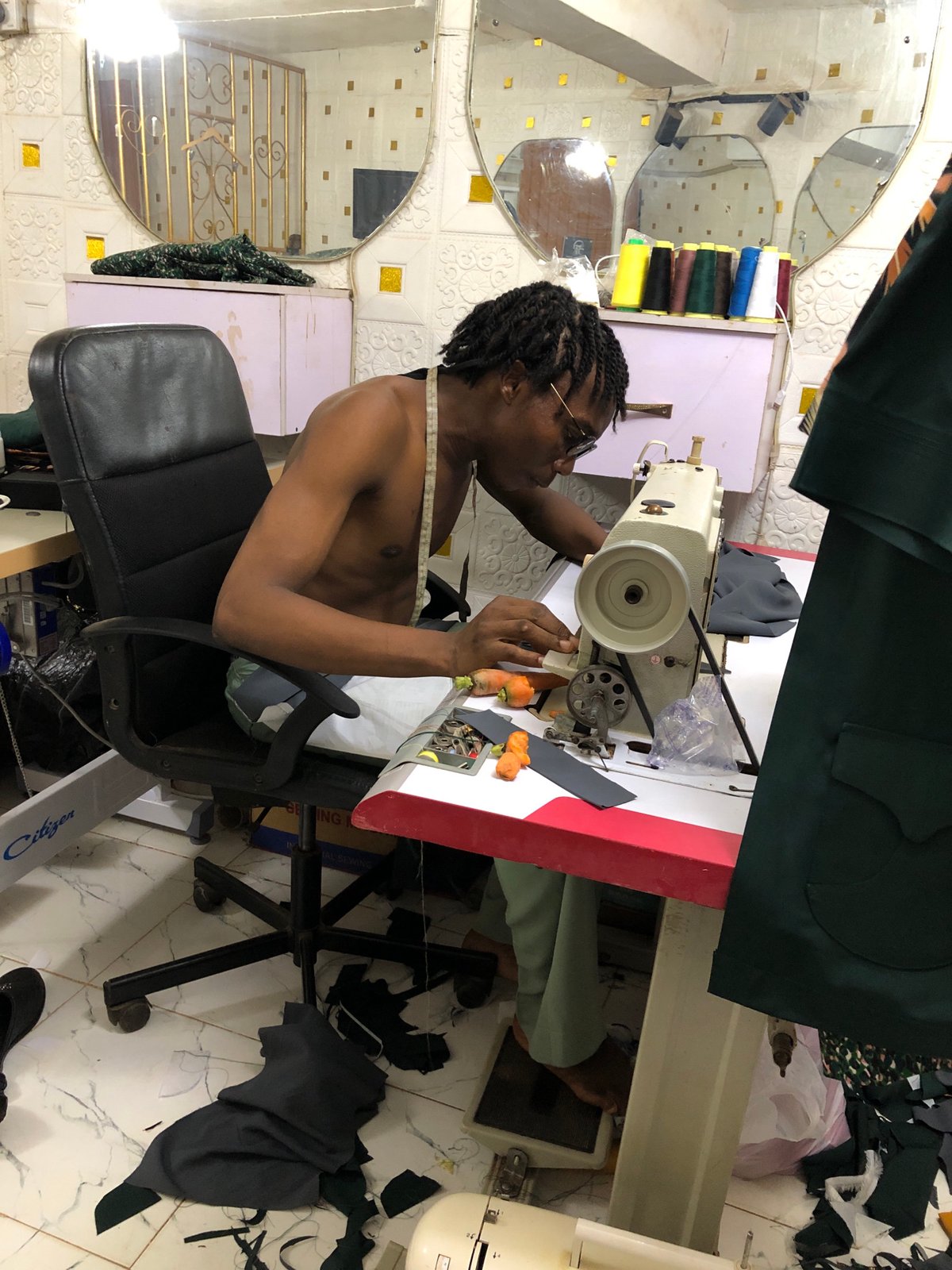 Tailor works industrial sewing machine at Onitsha workshop