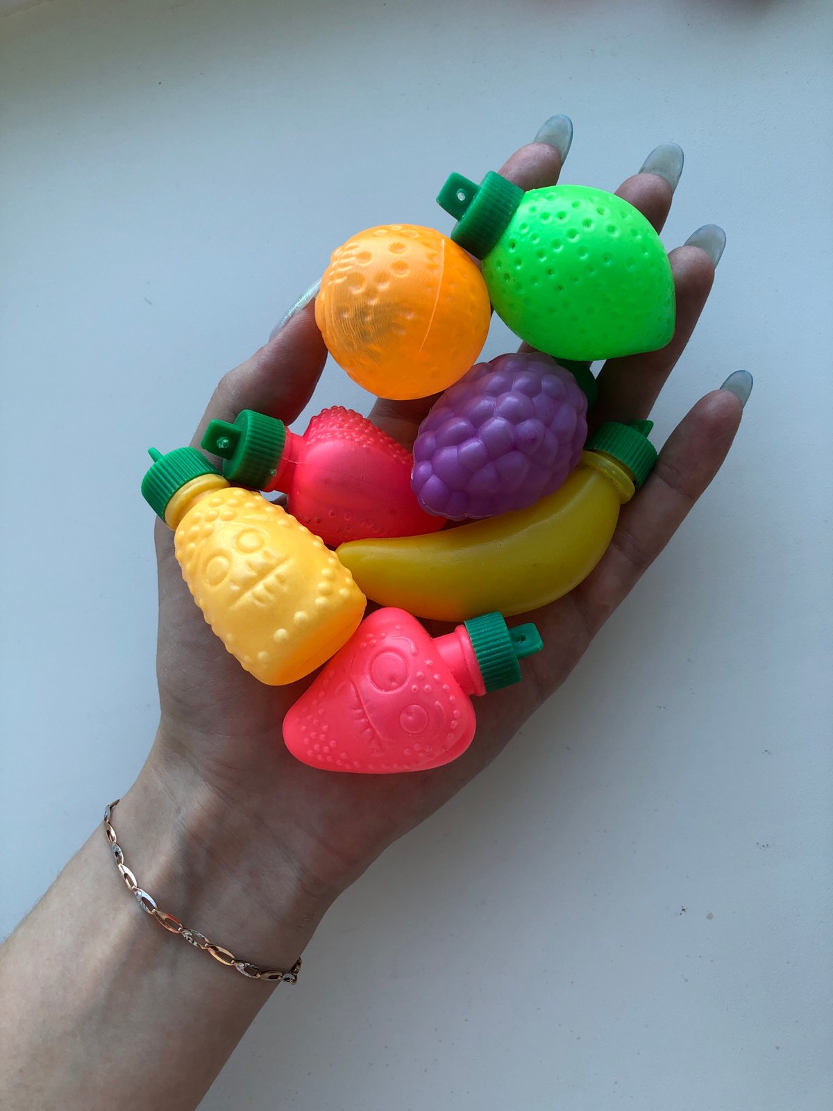 Person handles plastic toy fruits in Noviy, Russia