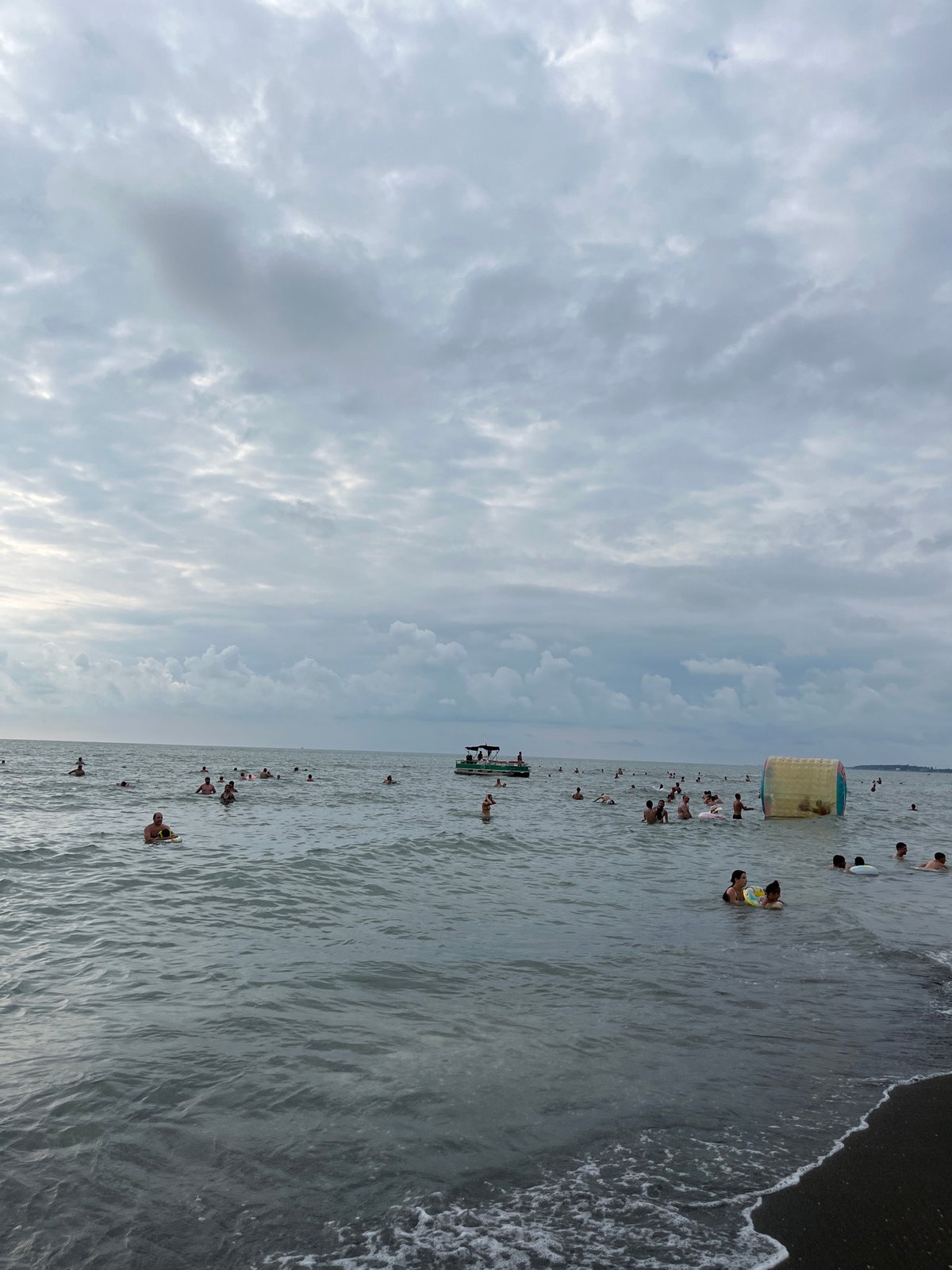 Crowded summer day at Ureki's Black Sea black sand beach