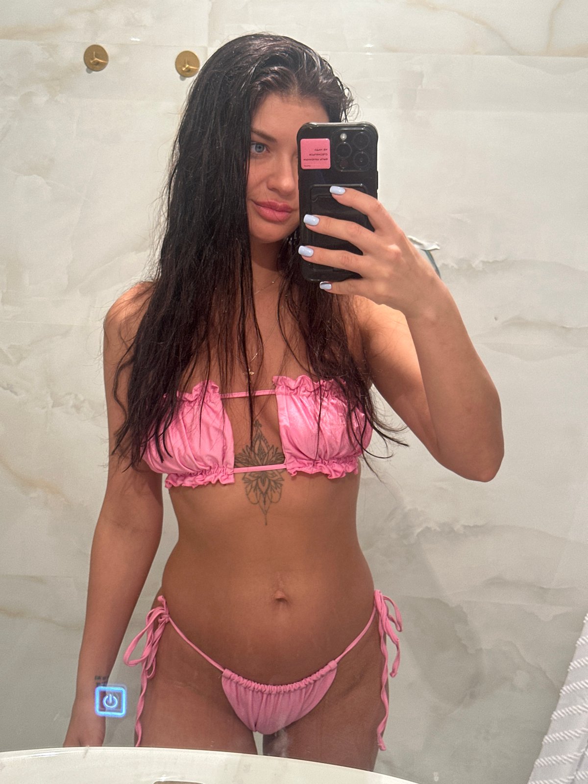 Woman takes bathroom mirror selfie in Angelovo, Russia