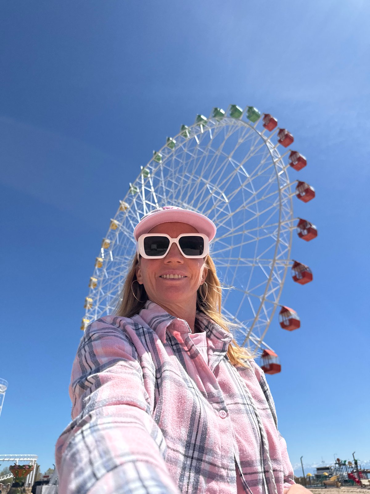 Tourist takes selfies at Ferris wheel pier in Kyrgyzstan