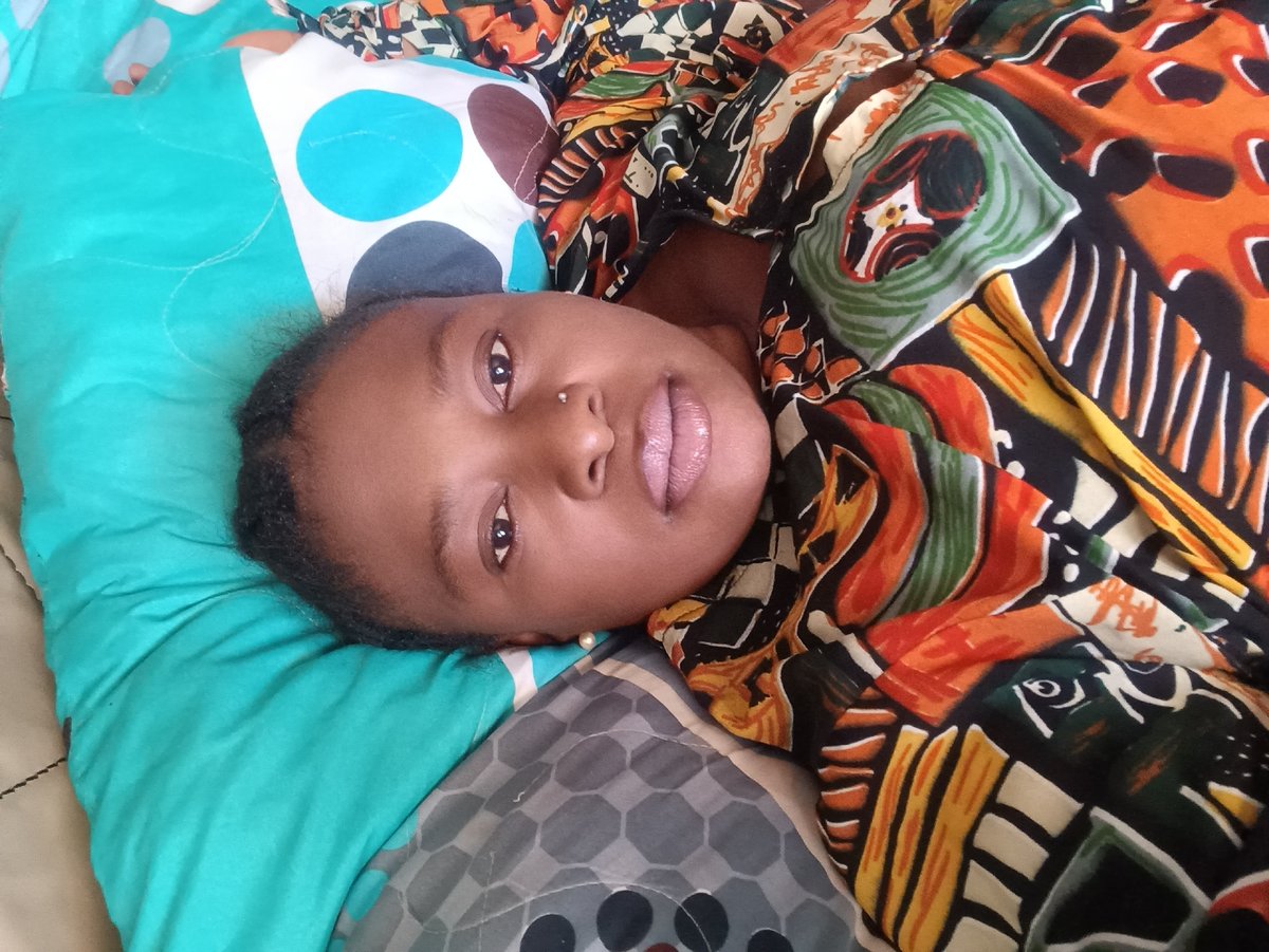 Woman rests on patterned bedding in Jos, Nigeria