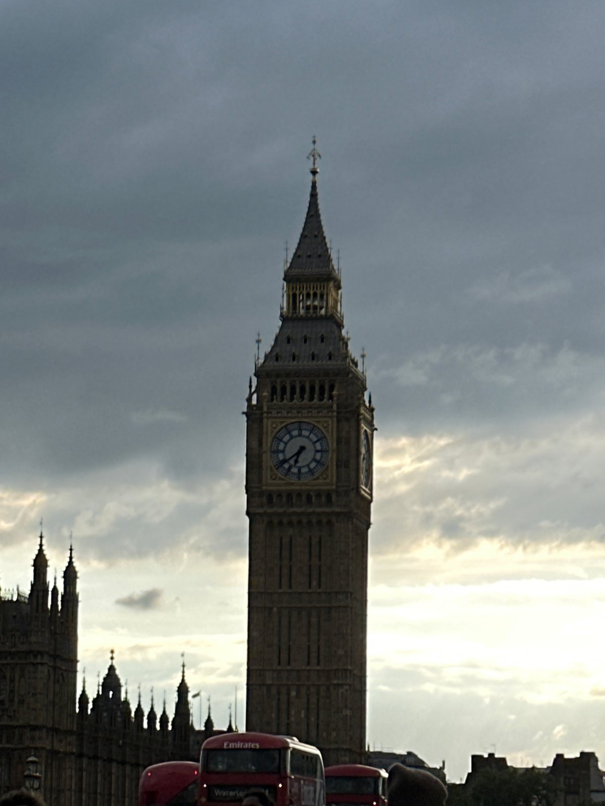 Red bus spotted near Big Ben under overcast London sky