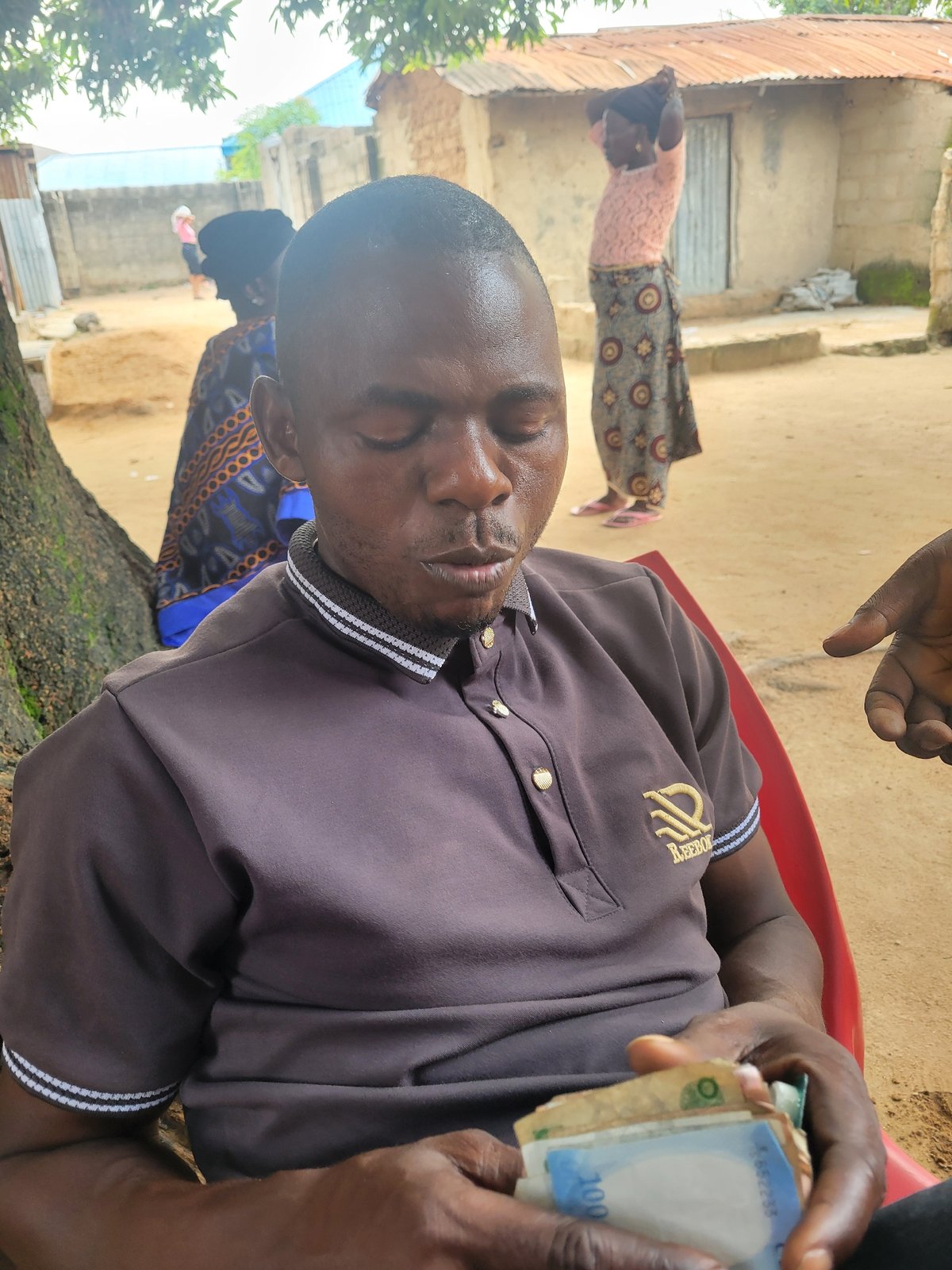 Casual outdoor gathering under a tree in Madalla, Nigeria