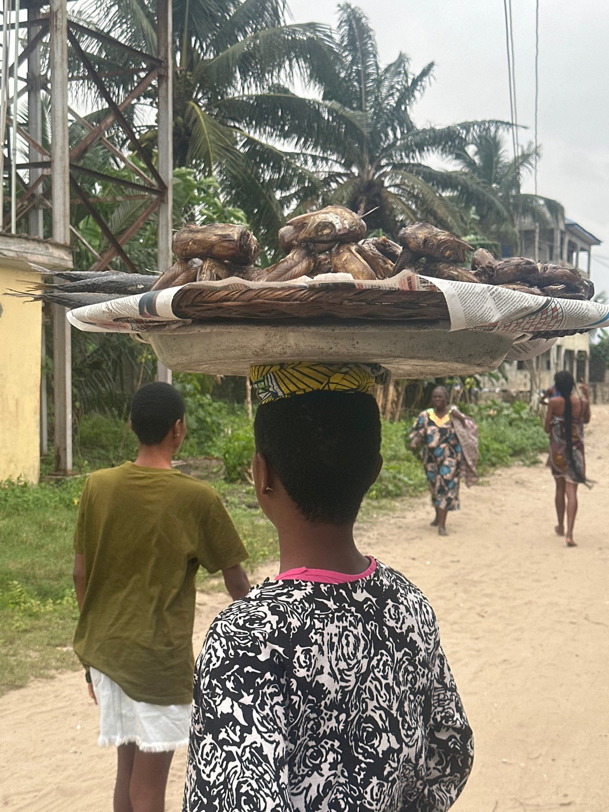 Everyday life in Badagry's sandy streets on a cloudy afternoon