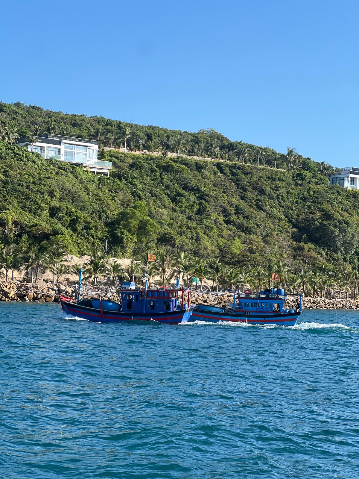 Passenger boat sails along rocky coast in Vietnam