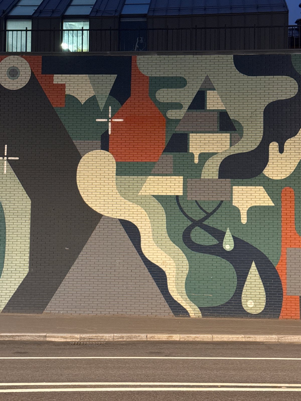 Nighttime urban documentation captures mural, bridge scene, illuminated building