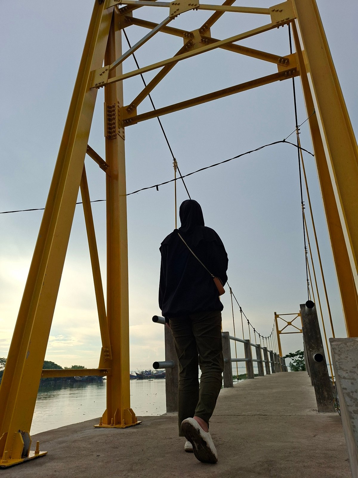 Person in black hijab visits multiple waterfront locations in Lhokseumawe