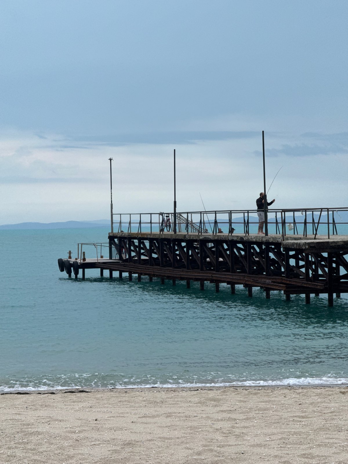 Woman documents beach visit in Ravda, Bulgaria on overcast day