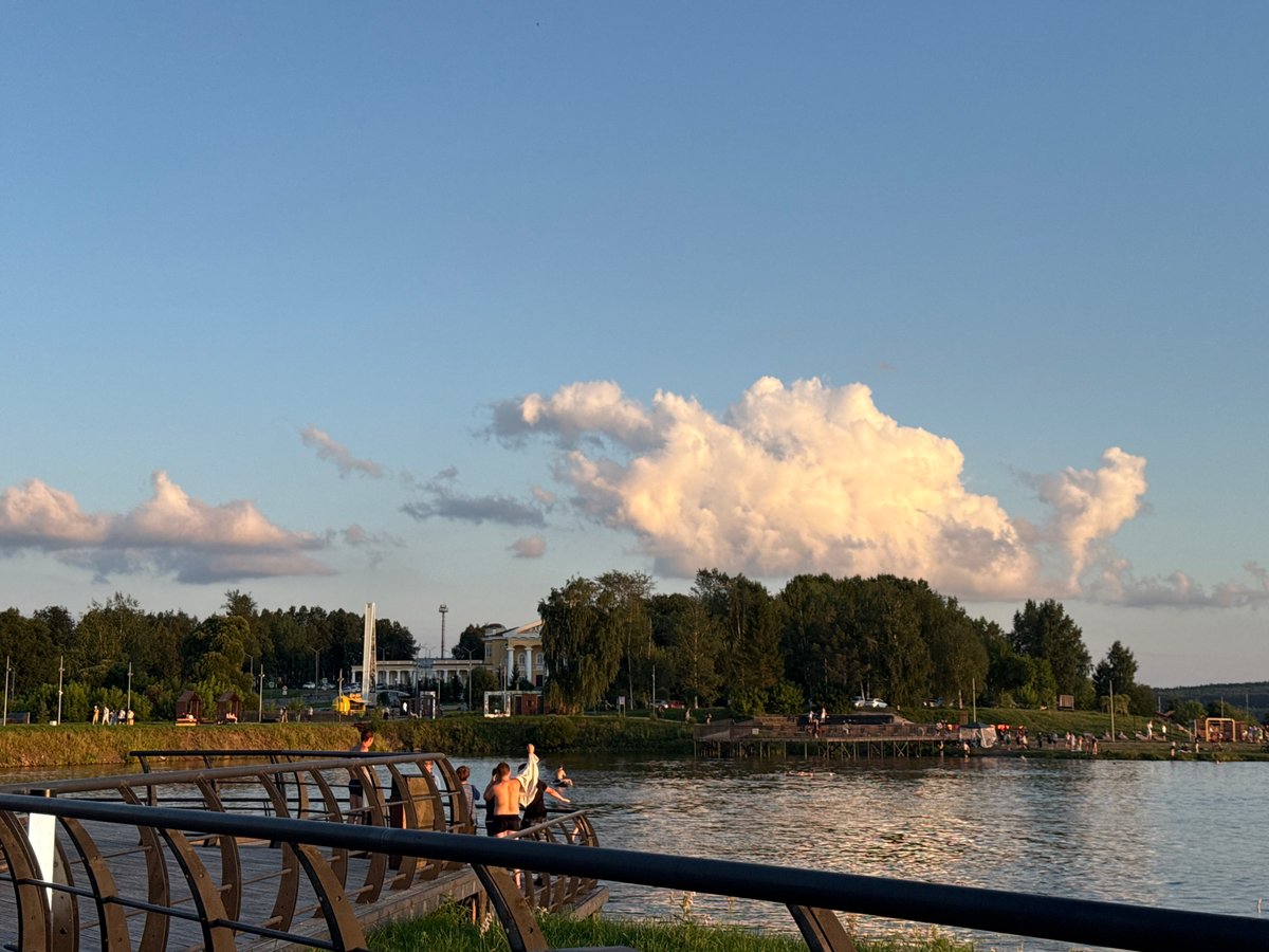 Curious dog explores Lysva's waterfront boardwalk at sunset