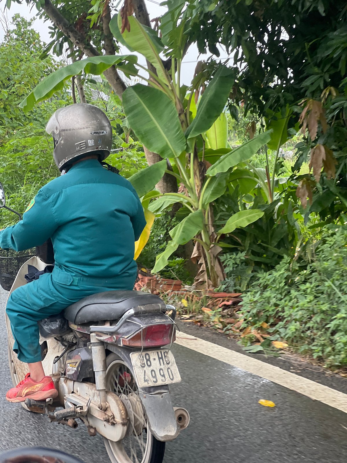 Hanoi school complex and motorcycle rider, cloudy morning