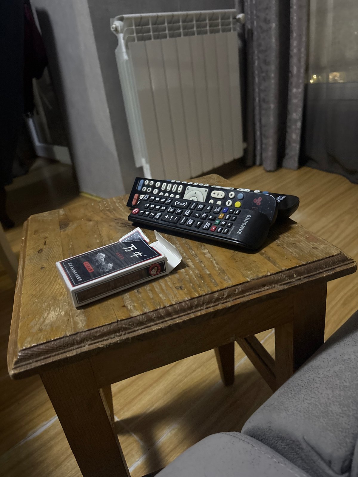 Personal items documented on wooden surface in dim lighting