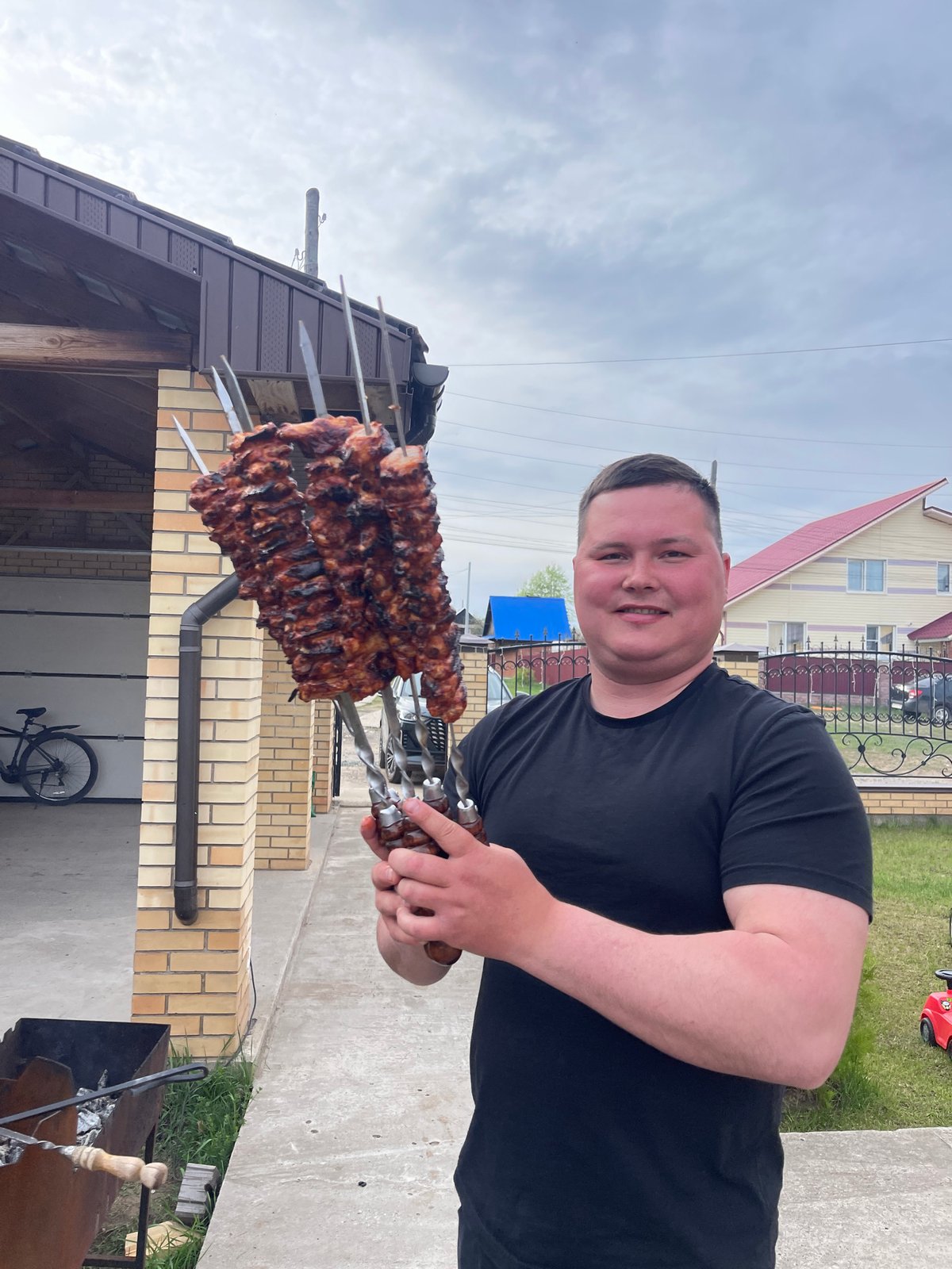 Man grills marinated meat outdoors in Chaikovsky, Russia